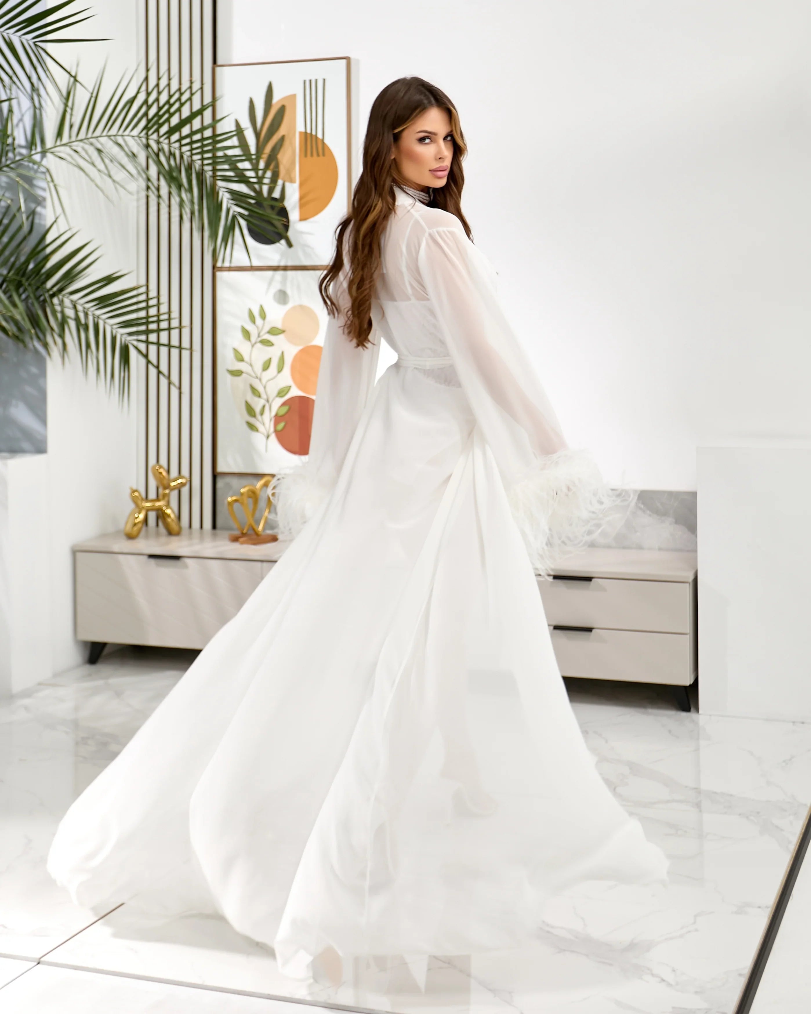 Bride getting ready in white chiffon feather bridal robe for wedding morning